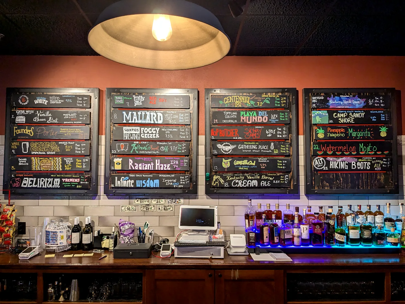 The bar under a pendant lamp, with the painted tap boards on the wall