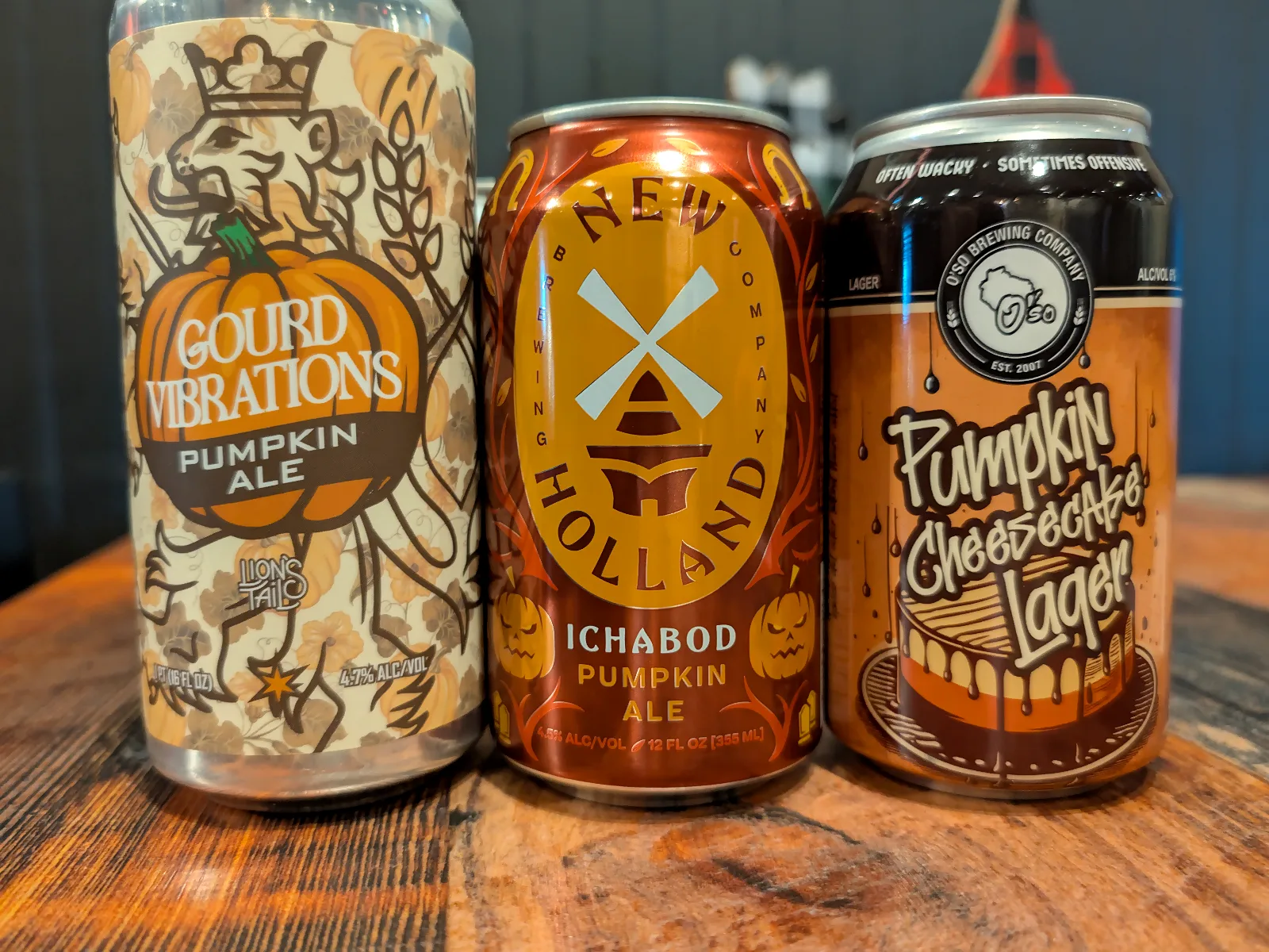 Three seasonal pumpkin beer cans on the bar